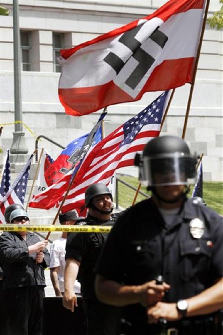 A Los Angeles police officer stands guard during a white supremacist rally at Los Angeles City Hall on Saturday April 17, 2010. Hundreds of counter-protestors carrying anti-Nazi signs have gathered in downtown Los Angeles where a white supremacist group is rallying. (AP Photo/Richard Vogel)